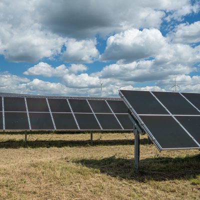 The solar panels in the grain field in the countryside under the cloudy sky